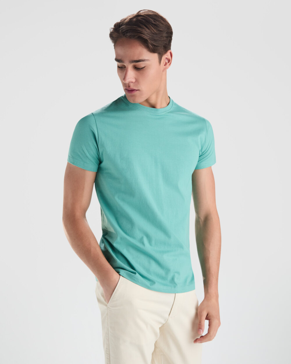 Hombre con camiseta verde y pantalón beige