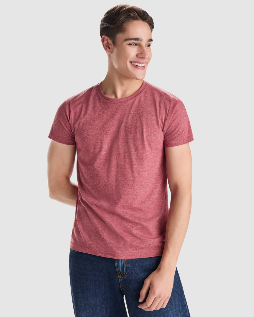 Joven sonriente con camiseta roja y vaqueros
