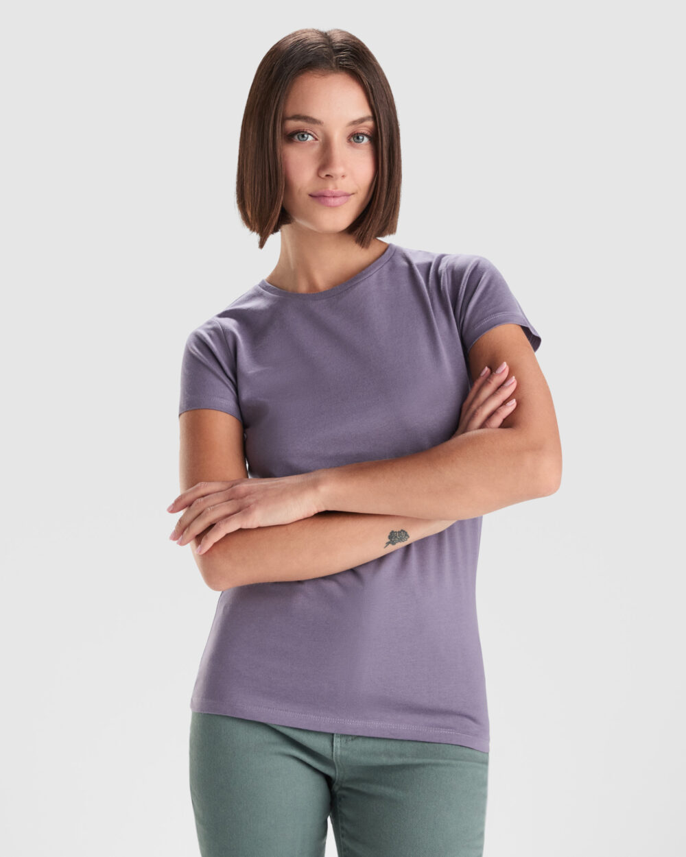 Mujer con camiseta morada y brazos cruzados