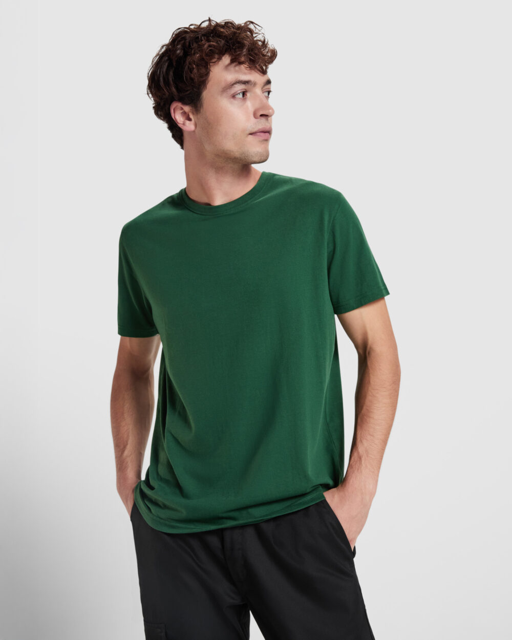 Hombre con camiseta verde sobre fondo neutro